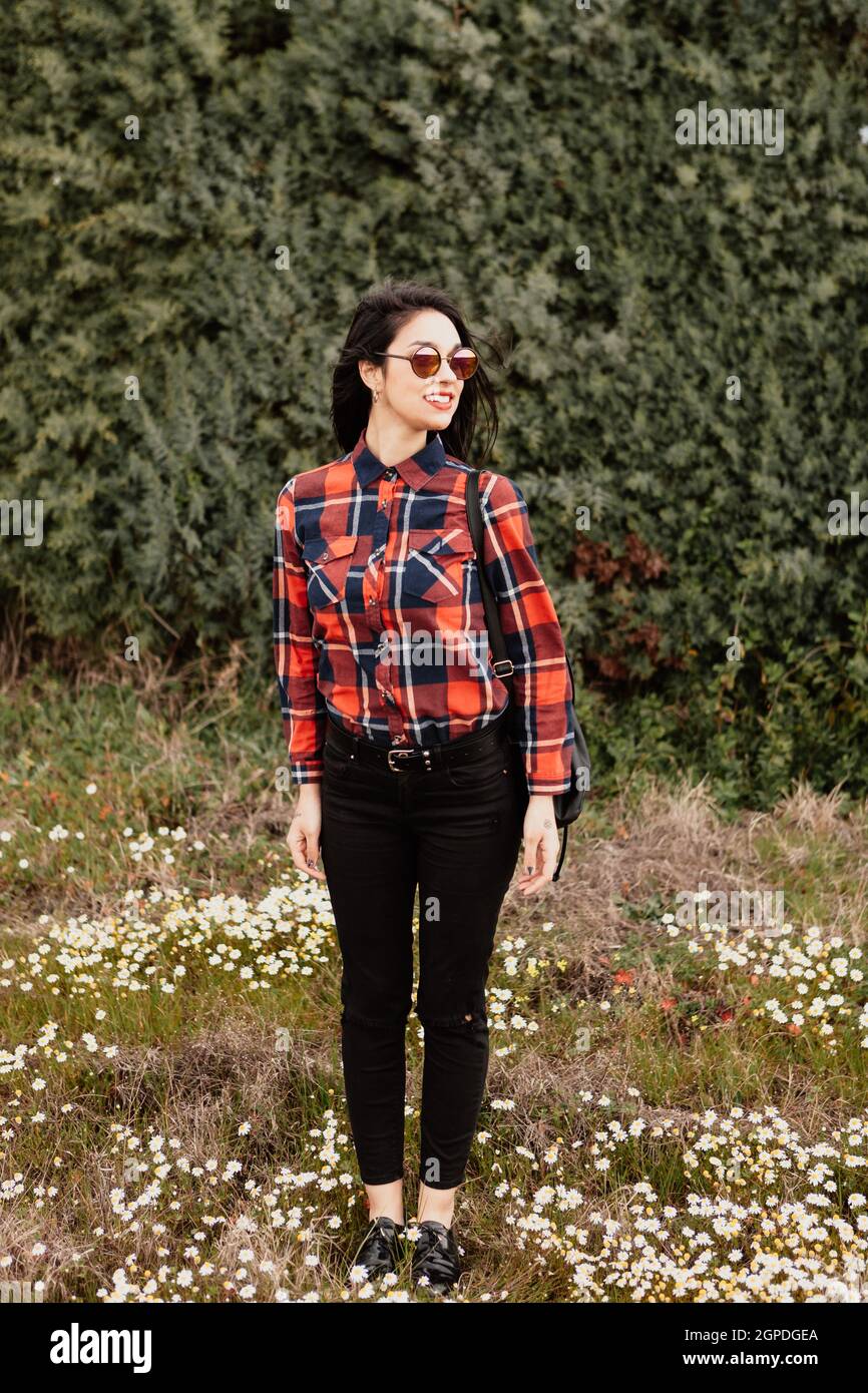 Bella bruna ragazza con red plaid shirt nel parco Foto Stock