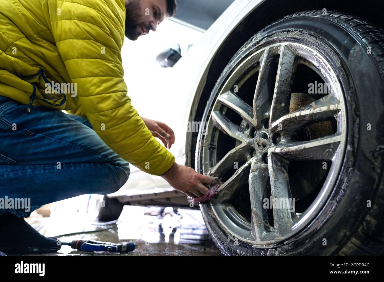 Pulizia manuale delle ruote con l'ausilio di spugne e schiuma. Foto Stock