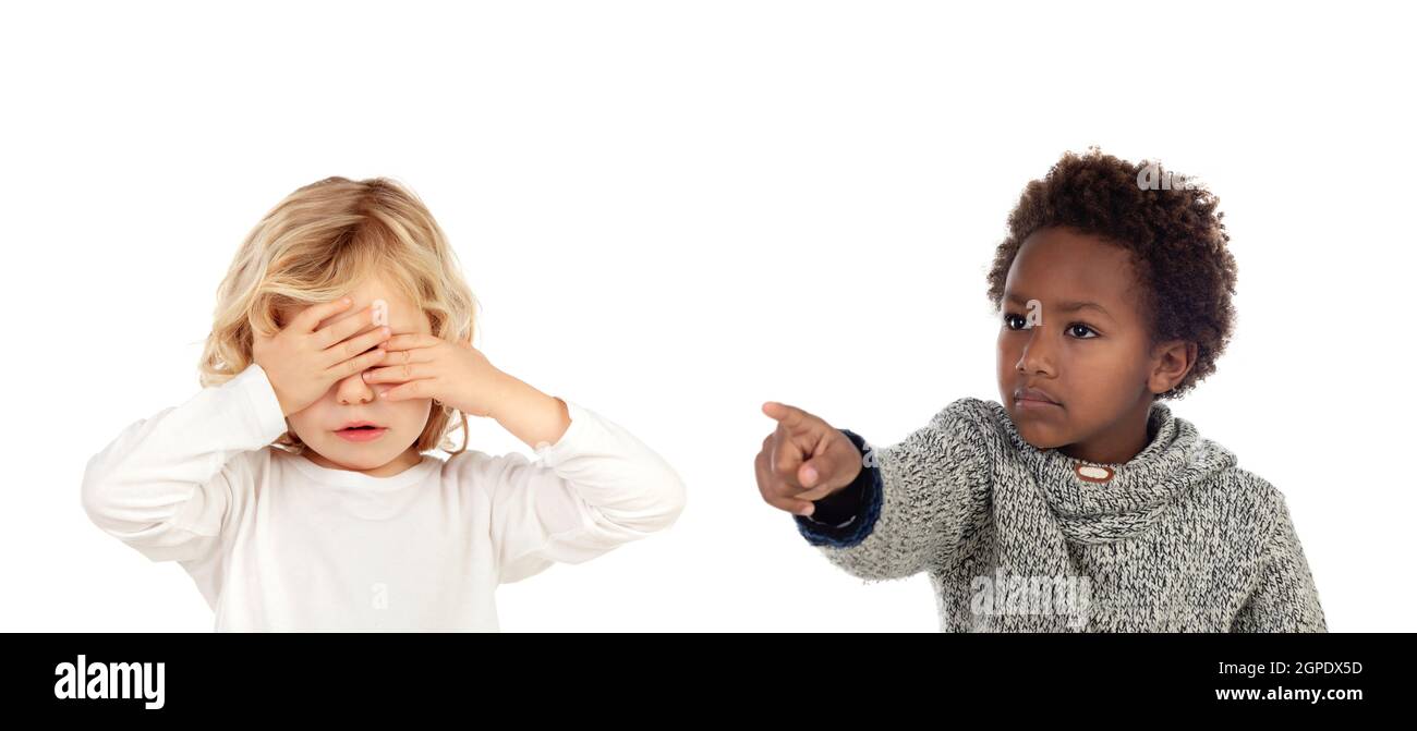 Bambino africano dicendo che un ordine al suo amico, che copre gli occhi isolati su sfondo bianco Foto Stock
