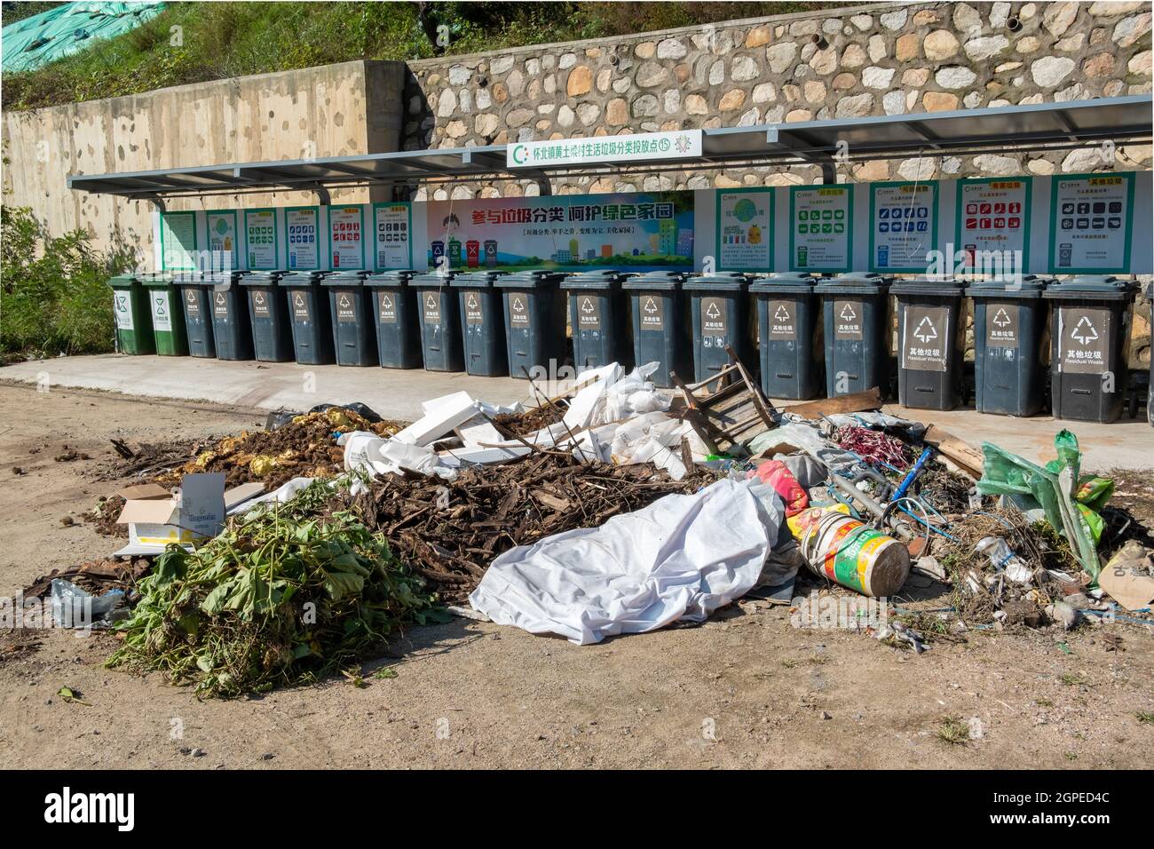 Una grande quantità di rifiuti viene scaricata al di fuori della struttura di raccolta rifiuti in un villaggio nel distretto di Huairou, Pechino, Cina. Foto Stock