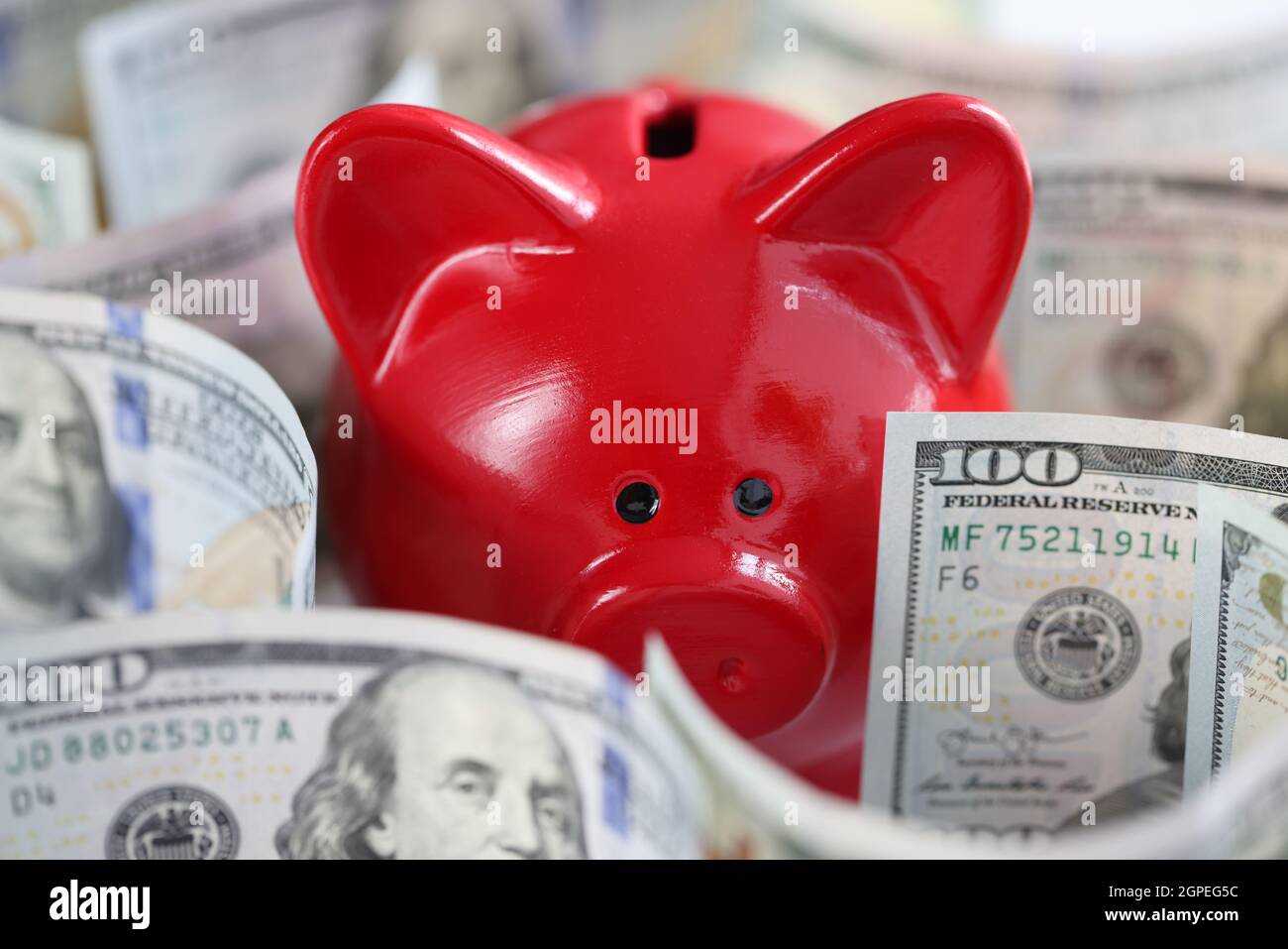 Red maiale Piggy banca e denaro americano in contanti sul tavolo Foto Stock