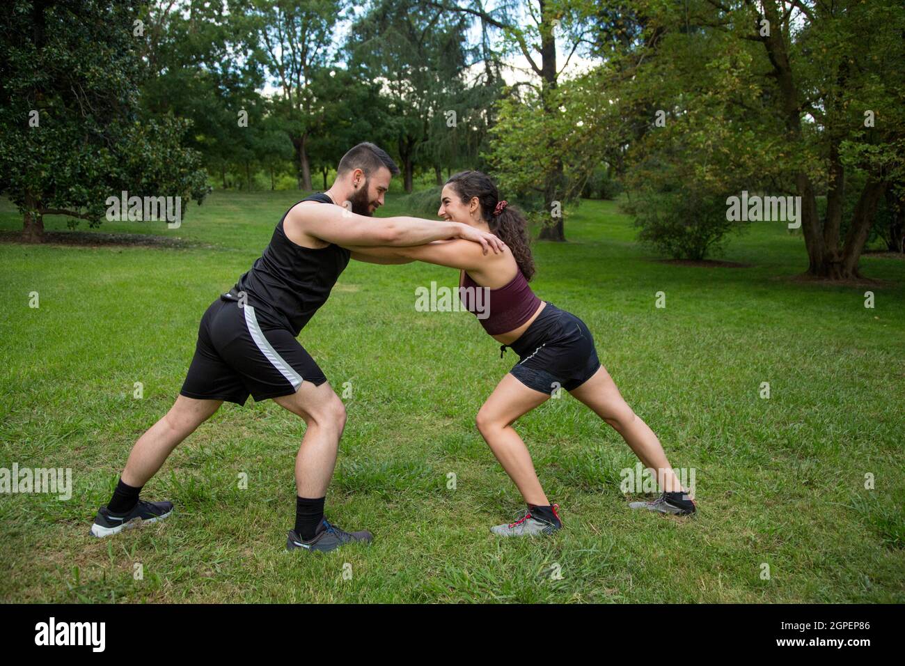 giovane uomo caucasico e donna coppia praticare la forza esercizio all'aperto Foto Stock
