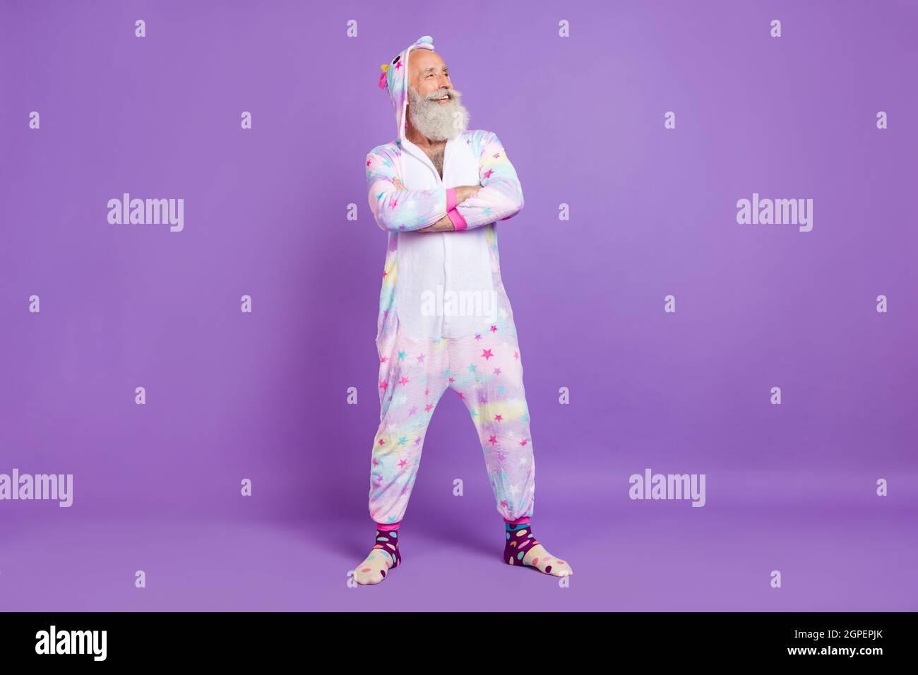 Foto del corpo pieno di allegro sicuro vecchio uomo indossare nightwear guardare vuoto spazio mani incrociate isolato su sfondo di colore viola Foto Stock