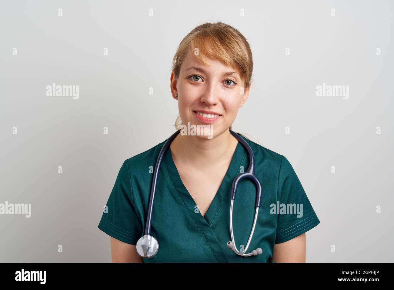 Sorridente assistente infermieristico femminile con fonendoscopio in  uniforme verde. Emergenza chirurgo Foto stock - Alamy