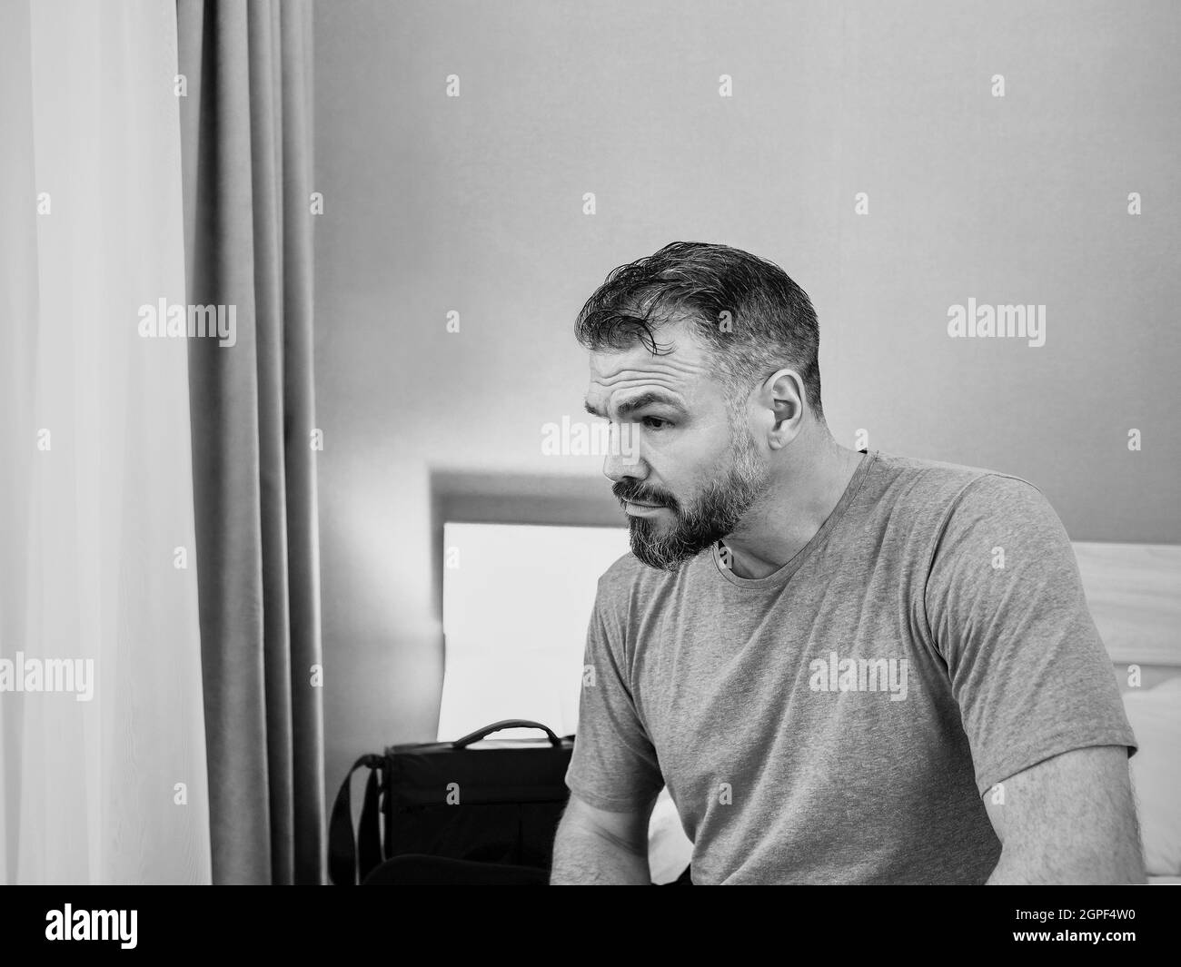 infelice bell'uomo seduto da solo sul letto in camera da letto. Divorzio, insonnia, depressione, problemi Foto Stock