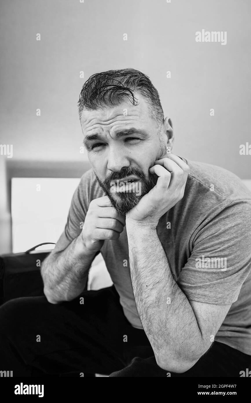 infelice bell'uomo seduto da solo sul letto in camera da letto. Divorzio, insonnia, depressione, problemi Foto Stock