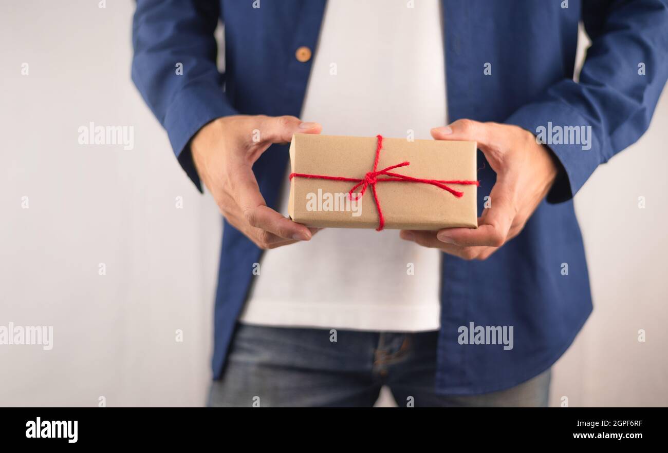 Scatola regalo di tenuta della mano del primo piano, scatola regalo di nuovo anno, scatola regalo di Natale, spazio di copia. Natale, anno di nascita, concetto di compleanno. Foto Stock