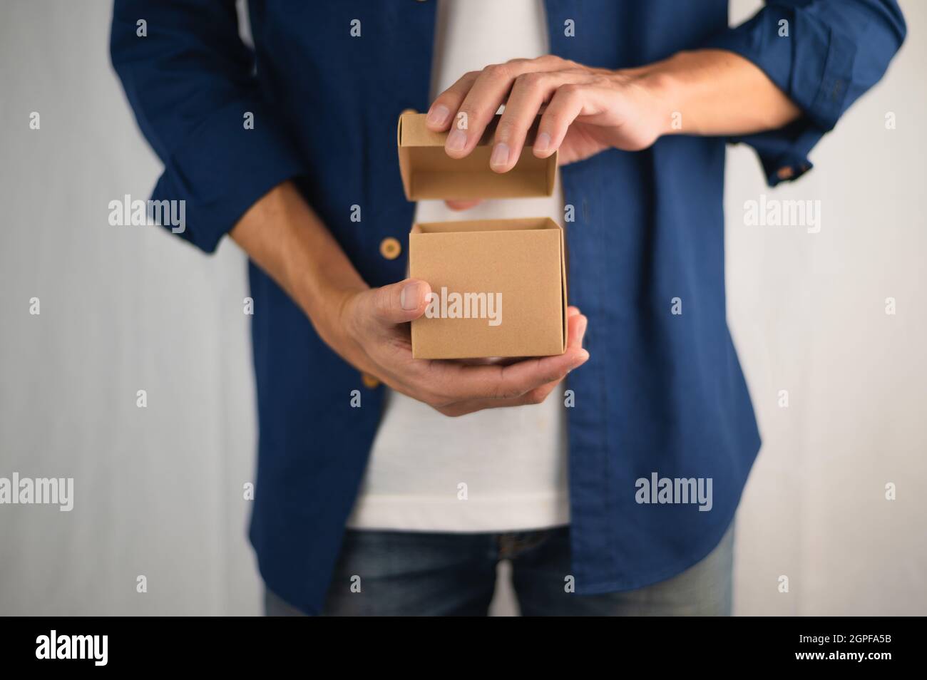 Scatola regalo di tenuta della mano del primo piano, scatola regalo di nuovo anno, scatola regalo di Natale, spazio di copia. Natale, anno di nascita, concetto di compleanno. Foto Stock