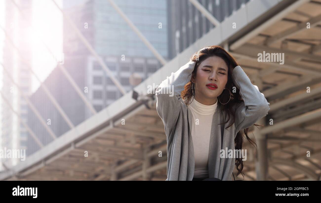 Stendere via. Saccheggiato. Donna di affari sparata seduta sulle scale dell'edificio di ufficio fuori. Depressione giovane donna da lavoro disoccupazione a causa del coronavirus cri Foto Stock