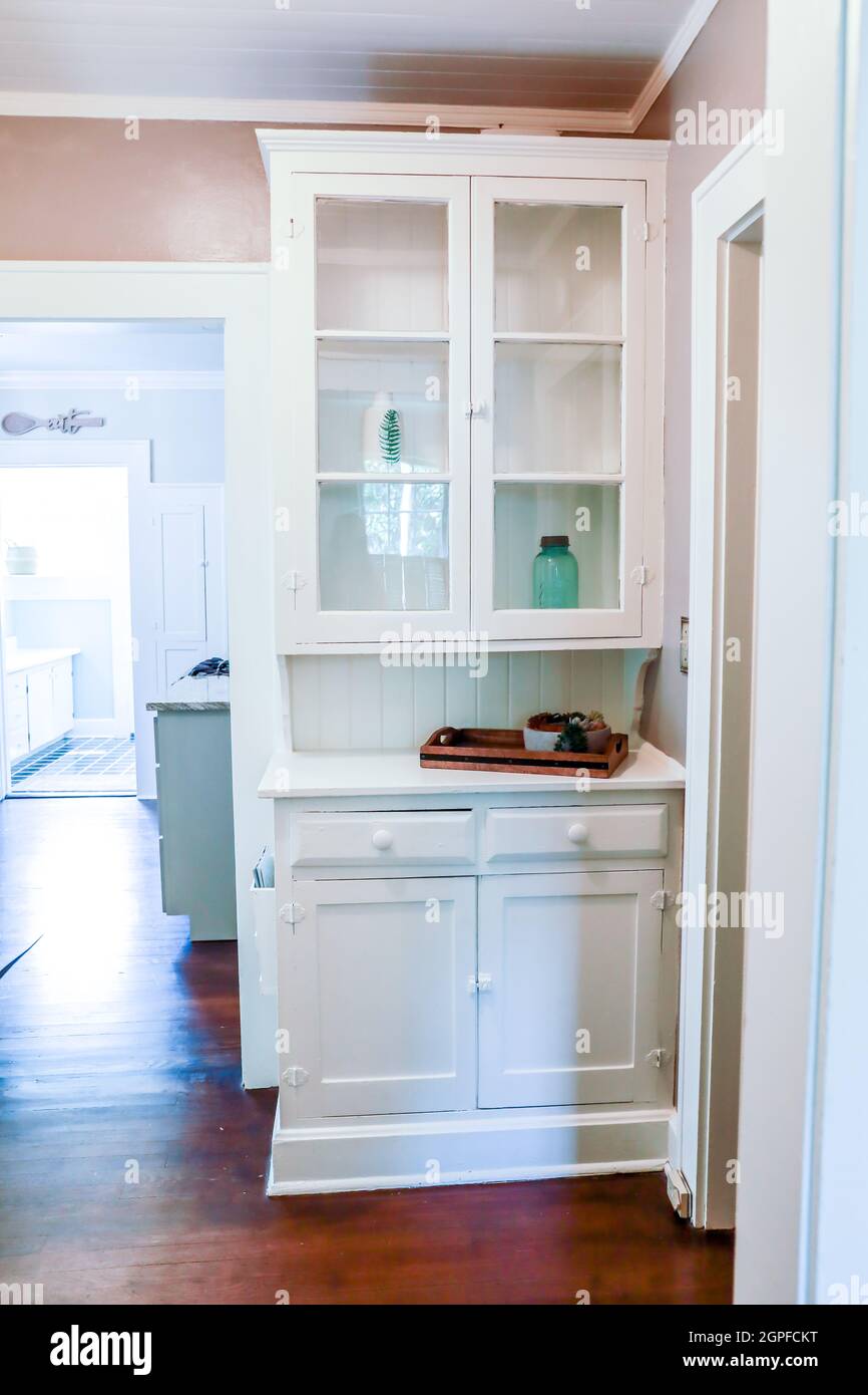 Una libreria originale in legno bianco costruita con porte di vetro in una casa di affitto a breve termine Foto Stock