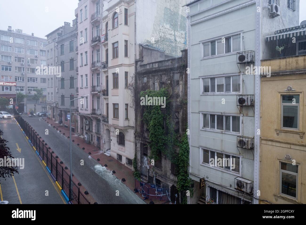 Beyoglu, Istanbul, Turchia - 06.18.2021: Una delle strade di Taksim con molti edifici durante le piogge pesanti e le inondazioni su strada in città in una nuvolosa Foto Stock