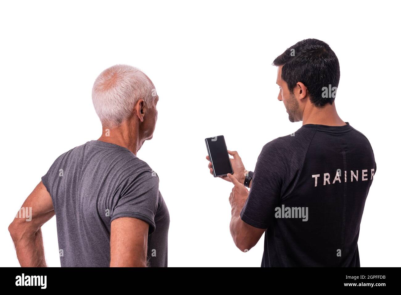 L'istruttore di fitness spiega a un uomo anziano come utilizzare un'applicazione software per la formazione su un fondo bianco isolato. Spazio di copia Foto Stock