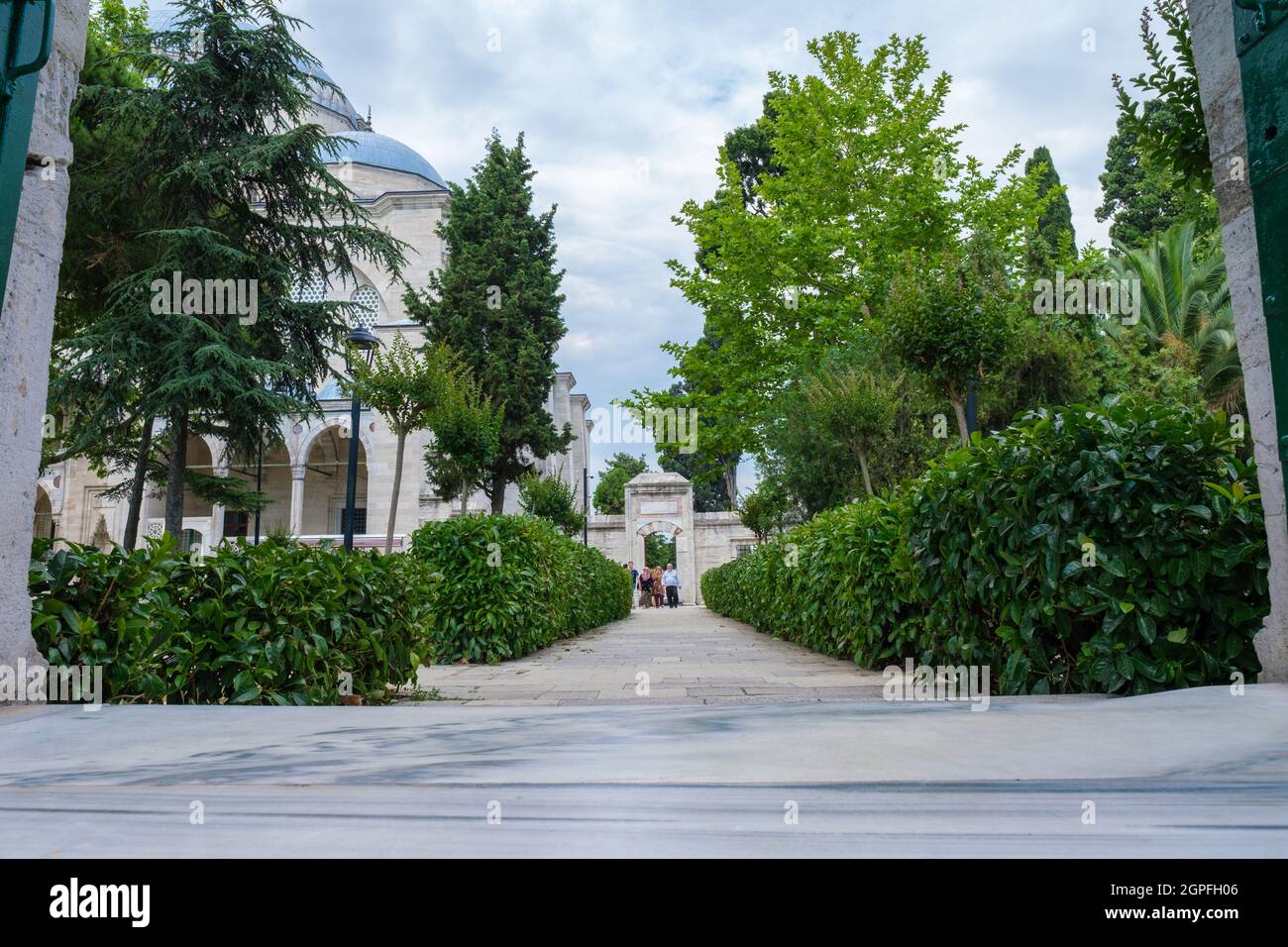 Fatih, Istanbul, Turchia - 07.05.2021: Porta della moschea di Suleymaniye e un sacco di alberi nel giardino e visitatori e diverse persone a piedi in giro Foto Stock