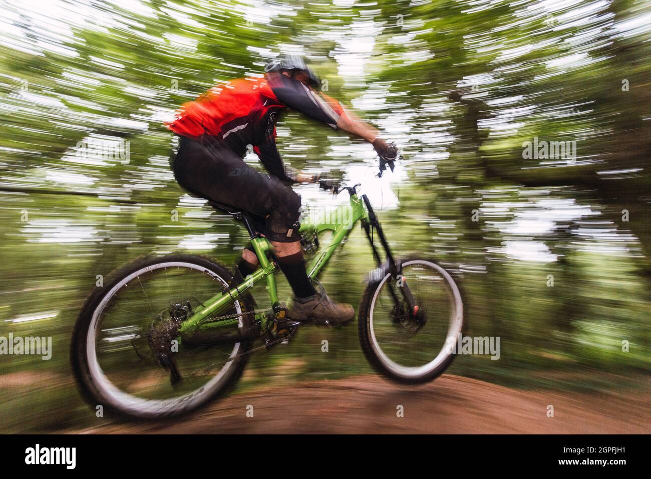 Basso angolo di visione dell uomo di eseguire acrobazie con la bicicletta in foresta Foto Stock