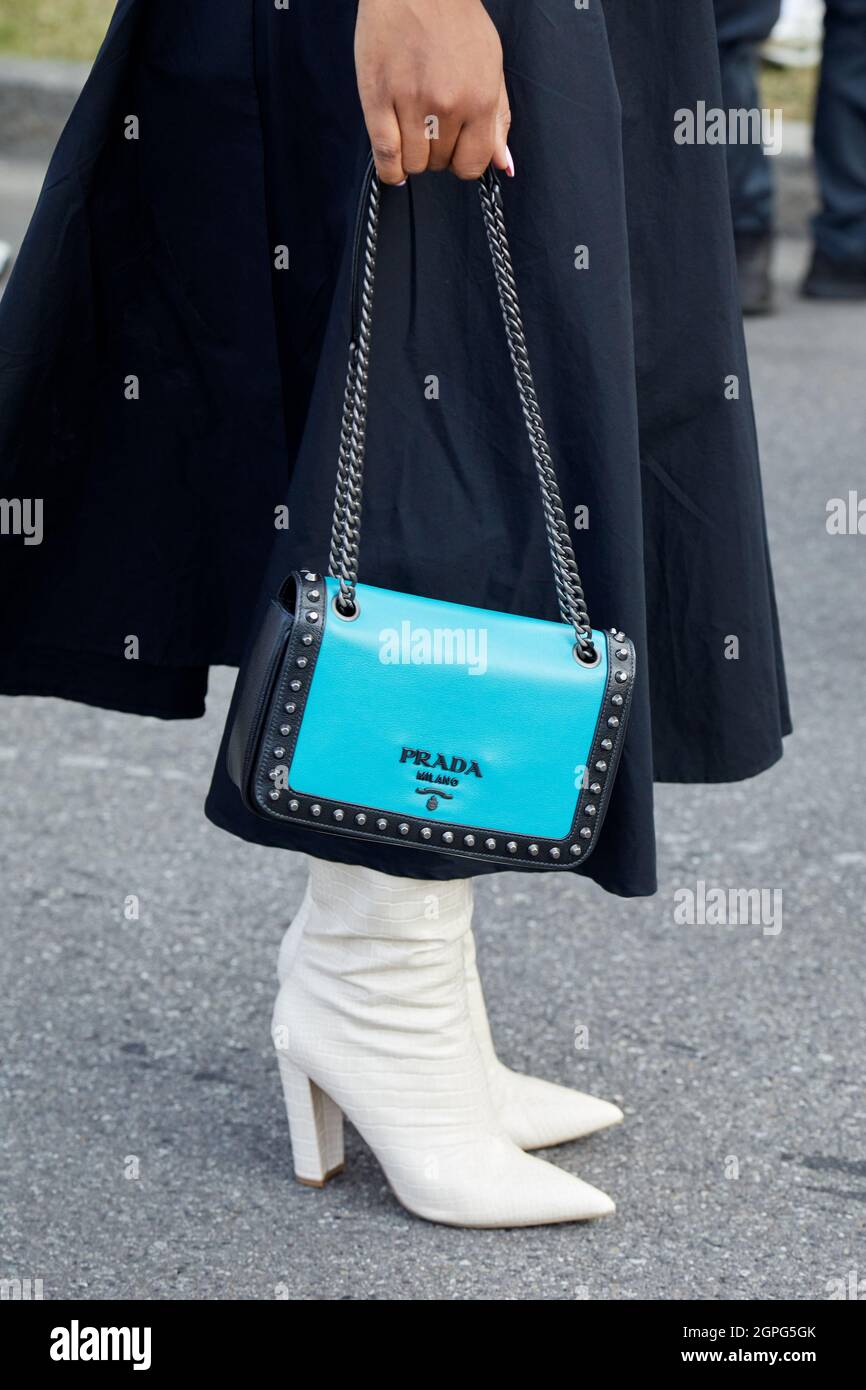 MILANO, ITALIA - 24 SETTEMBRE 2021: Donna con borsa Prada in pelle blu con  borchie e stivali bianchi prima della sfilata di moda Prada, Milano Fashion  Week Street s Foto stock - Alamy