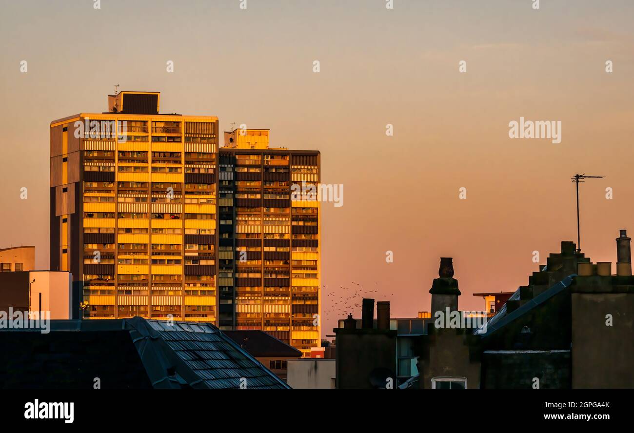 Alba di mattina presto sopra i tetti di Leith che brilla su Coupér Street Council alto blocco di appartamenti di consiglio di aumento, Edimburgo, Scozia, Regno Unito Foto Stock