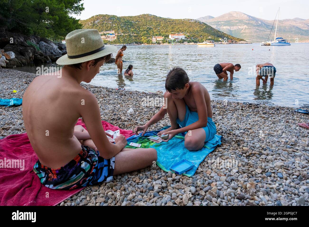 Croazia, Dalmazia, Isole Elafiti, Isola di Sipan, il porto di Sudurad, giocatori di carte su una spiaggia di ciottoli Foto Stock