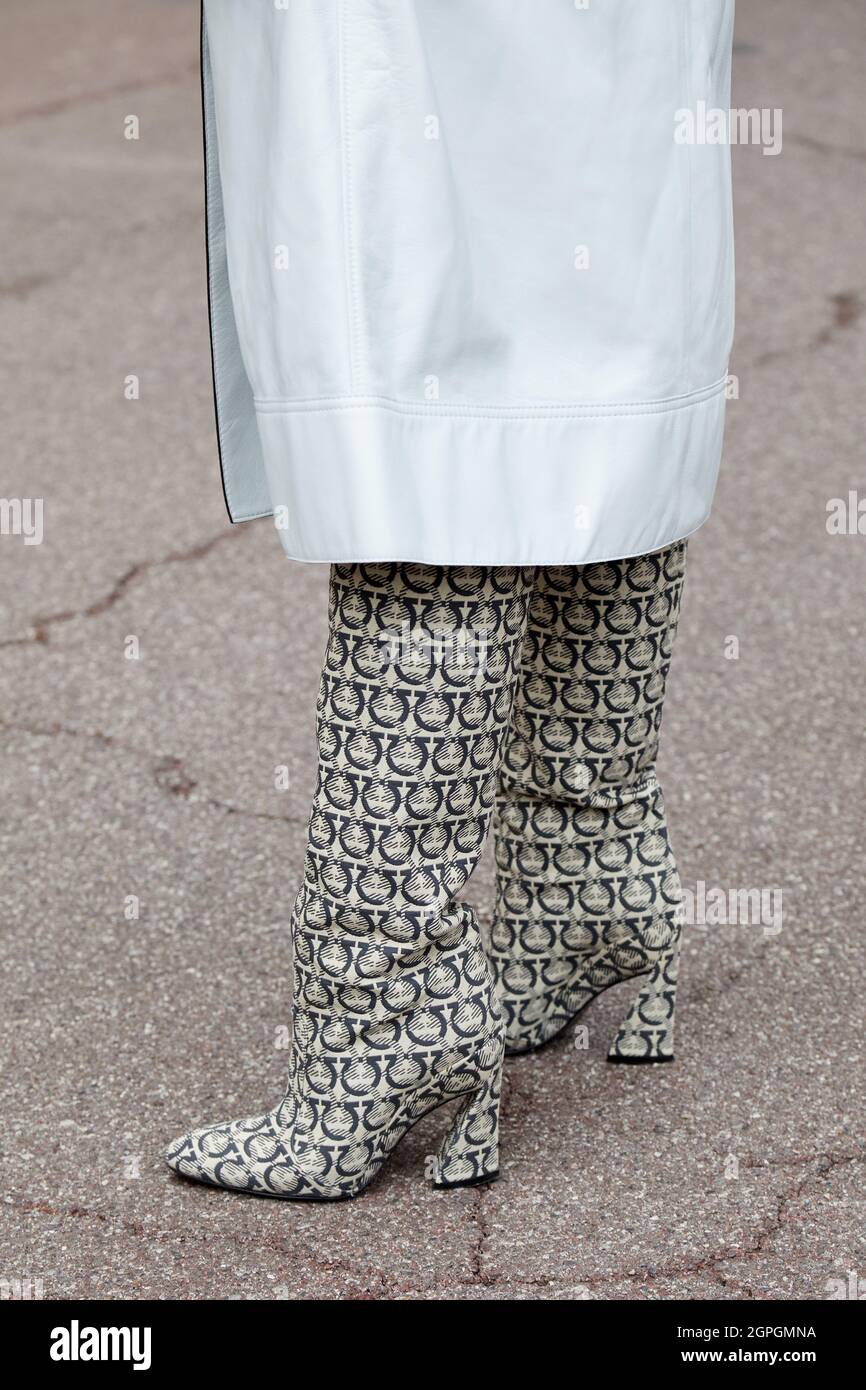 MILANO, ITALIA - 25 SETTEMBRE 2021: Donna con trench grigio pallido e stivali monogramma Ferragamo prima della sfilata di moda Salvatore Ferragamo di Mila Foto Stock