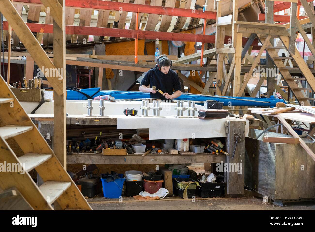 Francia, Finistere, Brest, Guip Shipyard, un falegname marino lavora con uno scalpello di legno Foto Stock