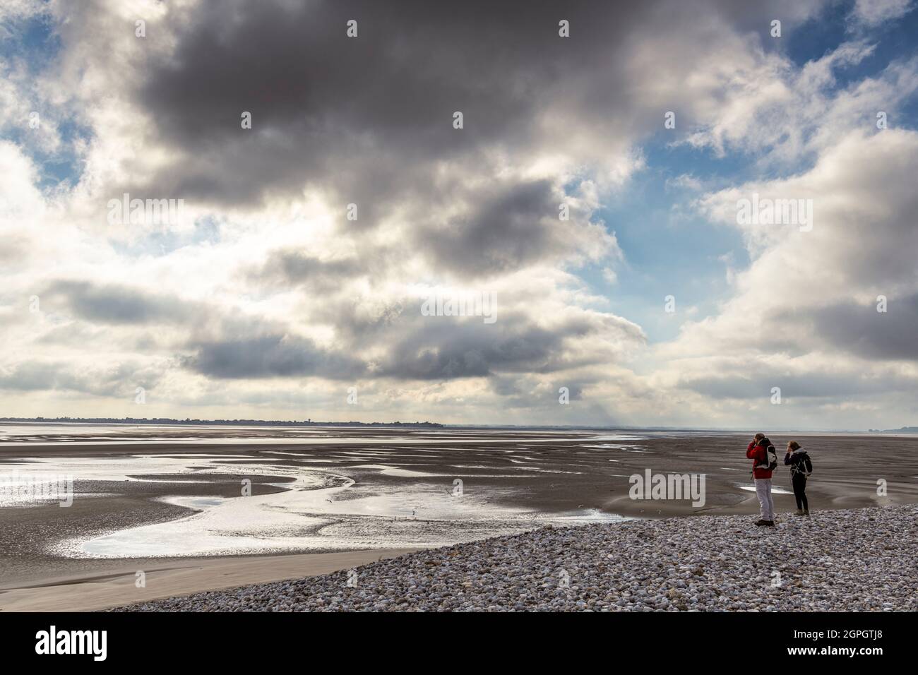 Francia, Somme, Baie de Somme, le Hourdel, Walkers sulle rive del sabbia alla Pointe du Hourdel sotto un cielo pesante, a bassa marea Foto Stock