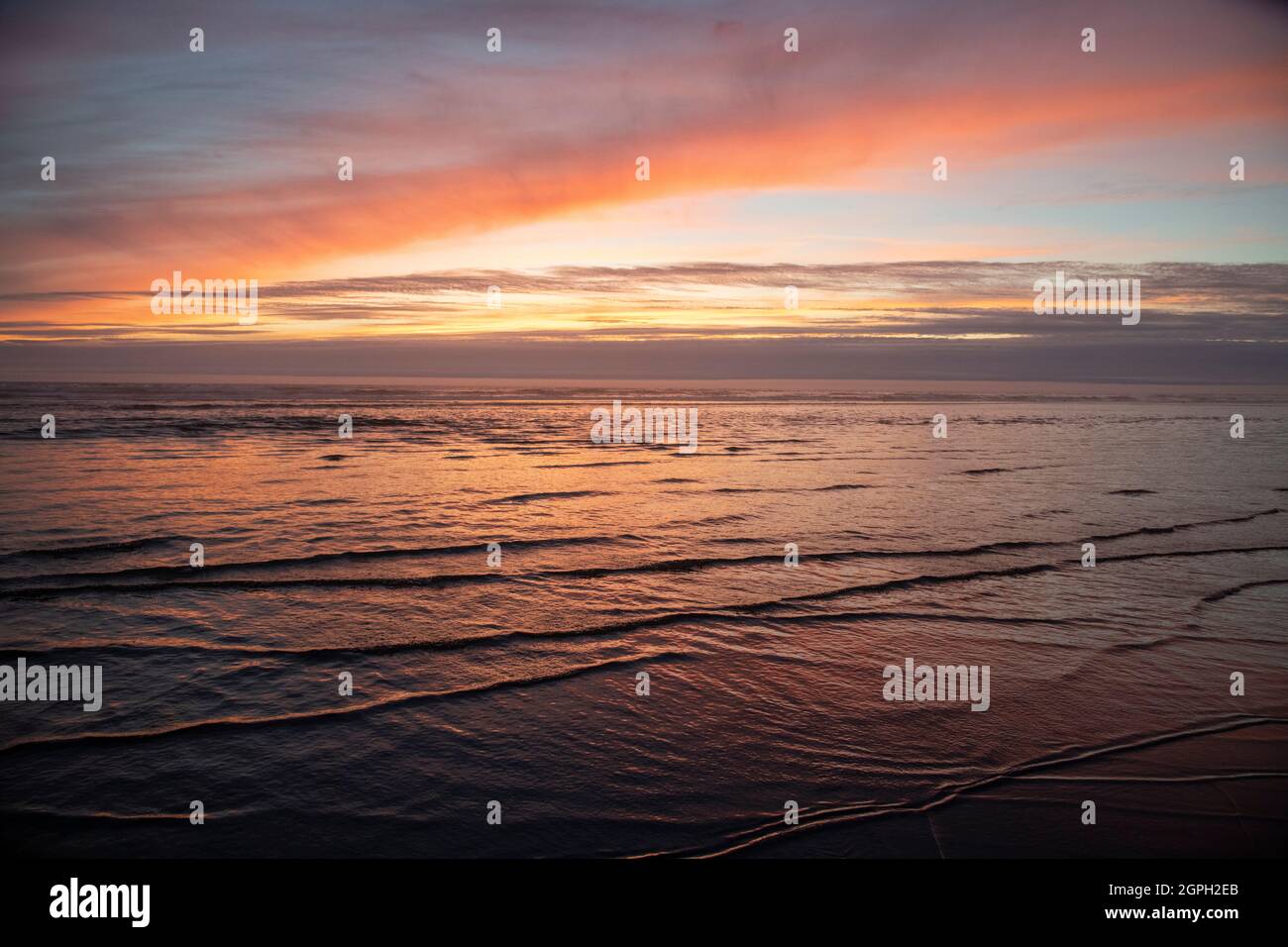 Tramonto sulla spiaggia con le onde Foto Stock