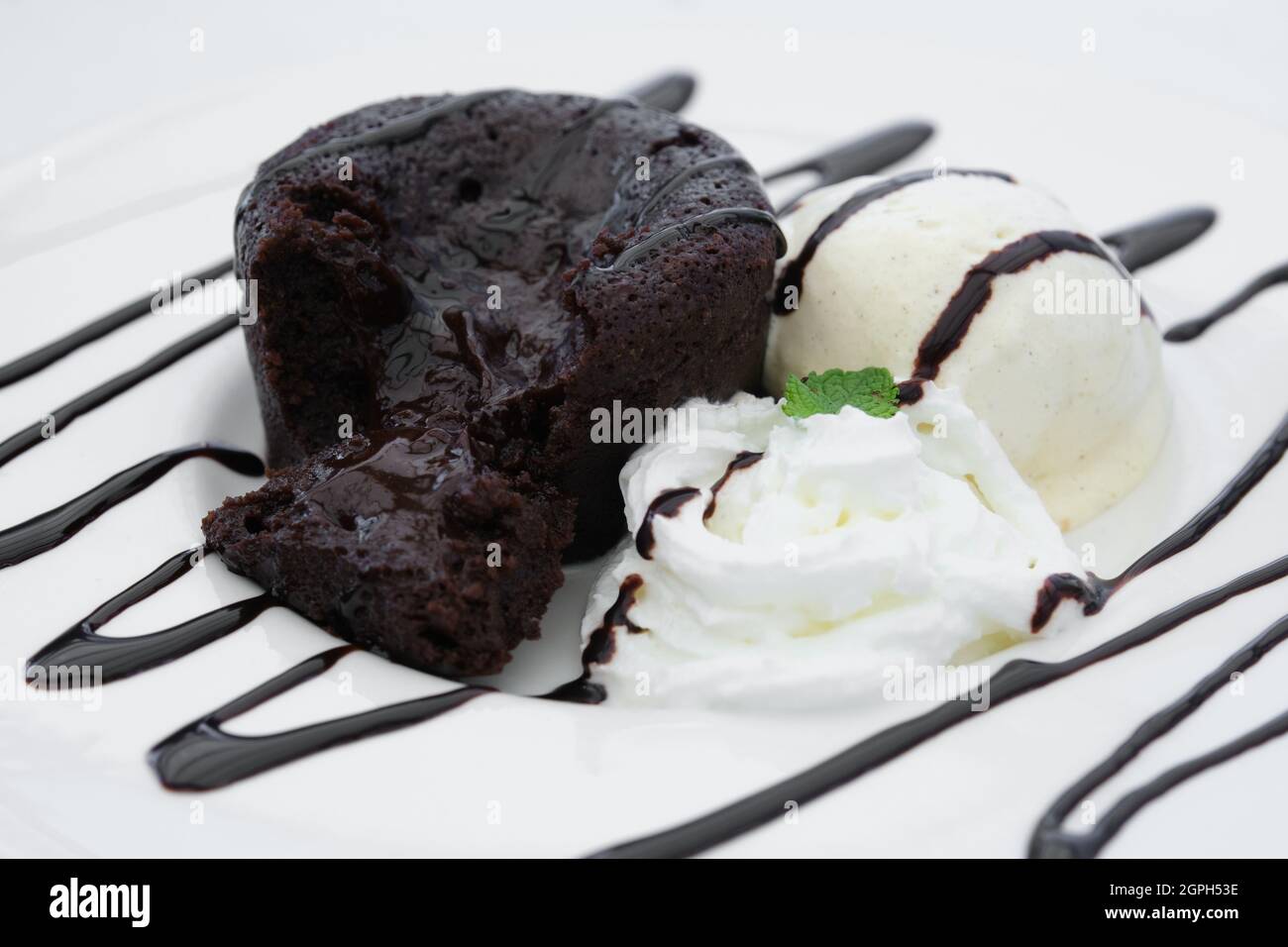 Coulant al cioccolato con panna e gelato alla vaniglia. Foto Stock