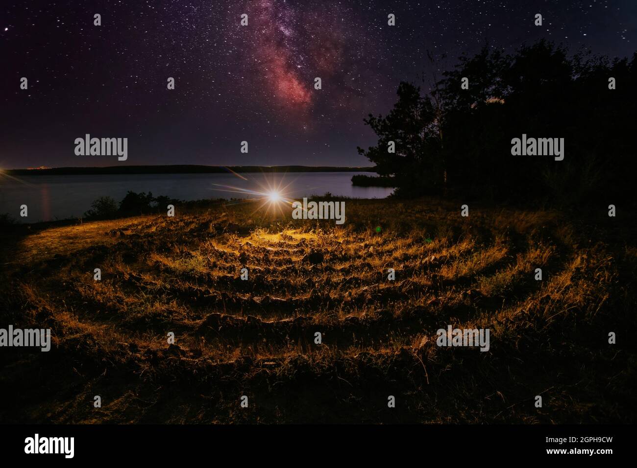 Labirinto a spirale fatto di pietre sulla costa nella notte stellata Foto Stock