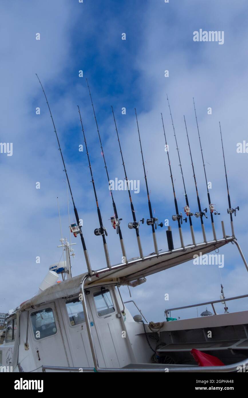 Una linea di dieci canne da pesca a mano su una Cornish Boat a St. Ives Harbour Harbour - UK Foto Stock