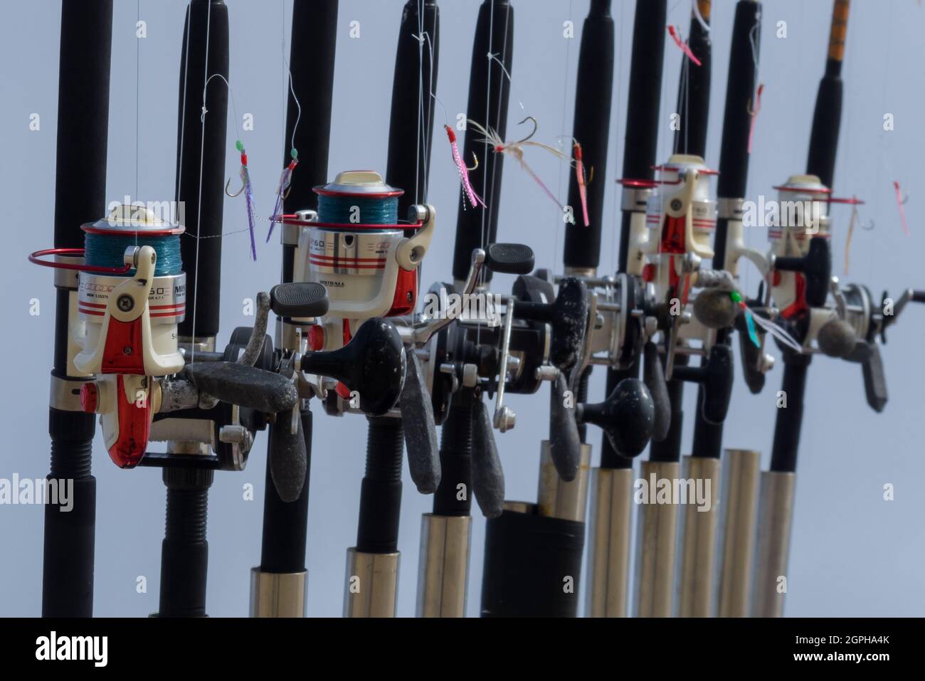 Una linea di dieci canne da pesca a mano su una Cornish Boat a St. Ives Harbour Harbour - UK Foto Stock