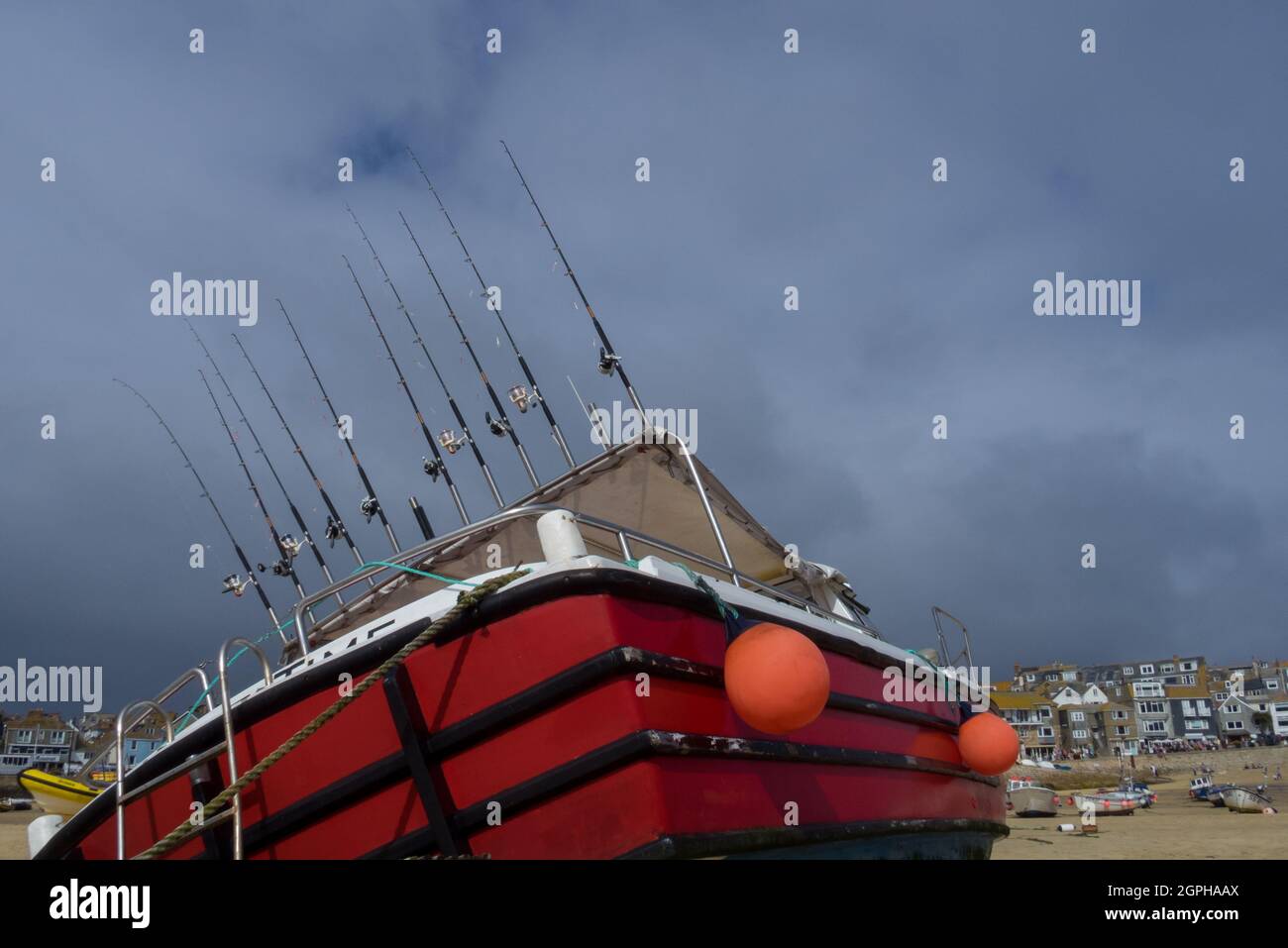 Una linea di dieci canne da pesca a mano su una Cornish Boat a St. Ives Harbour Harbour - UK Foto Stock