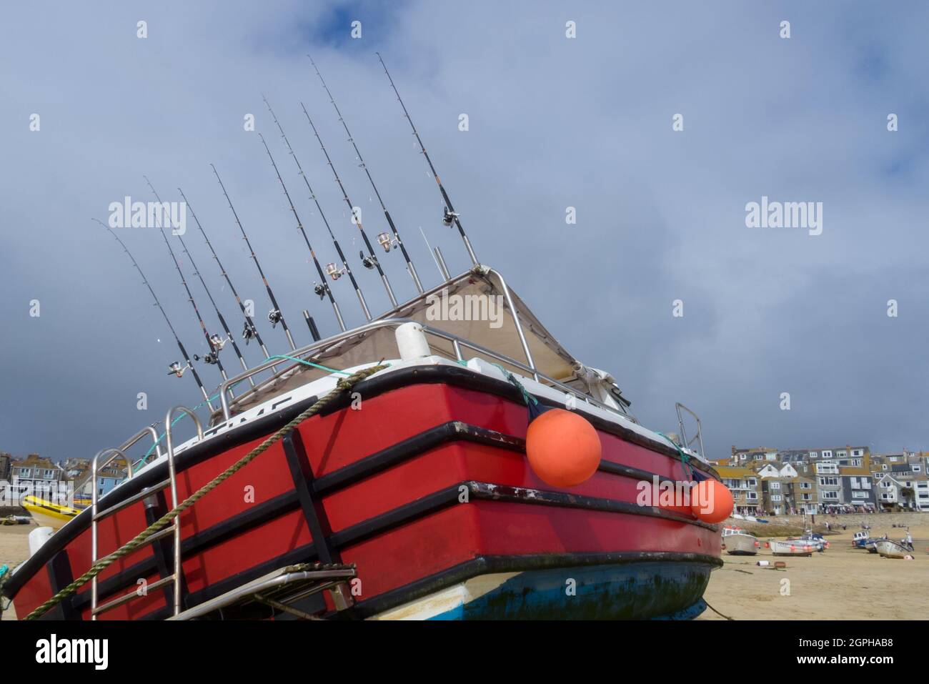 Una linea di dieci canne da pesca a mano su una Cornish Boat a St. Ives Harbour Harbour - UK Foto Stock