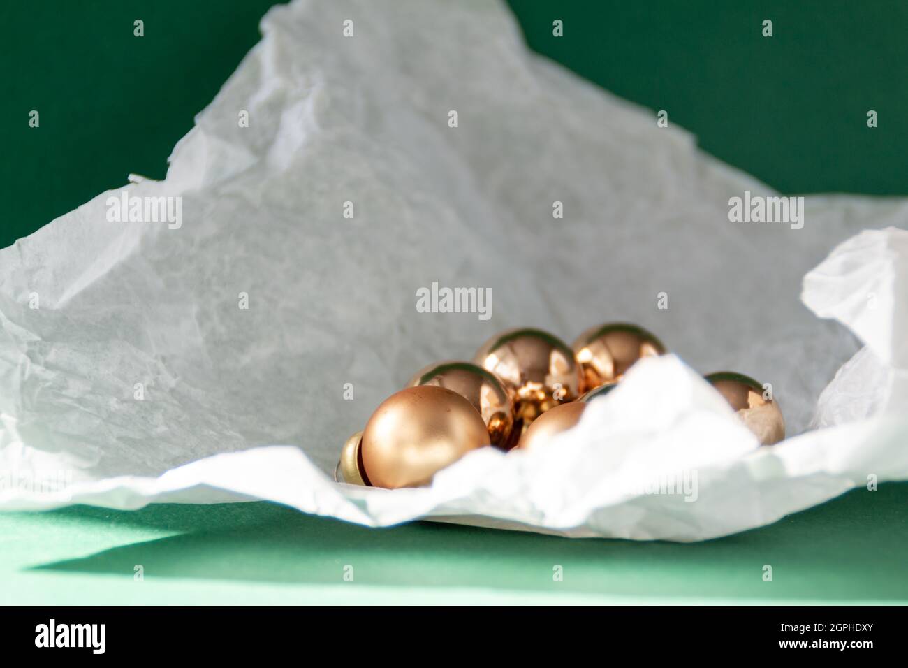 Decorazioni natalizie dorate in carta strappata su sfondo verde smeraldo Foto Stock