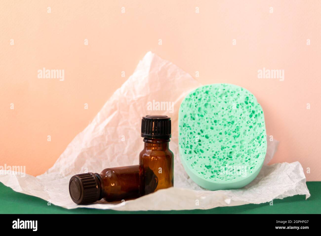 Bottiglia in vetro con olio aromatico e carta strappata, prodotti per la cura della pelle Foto Stock