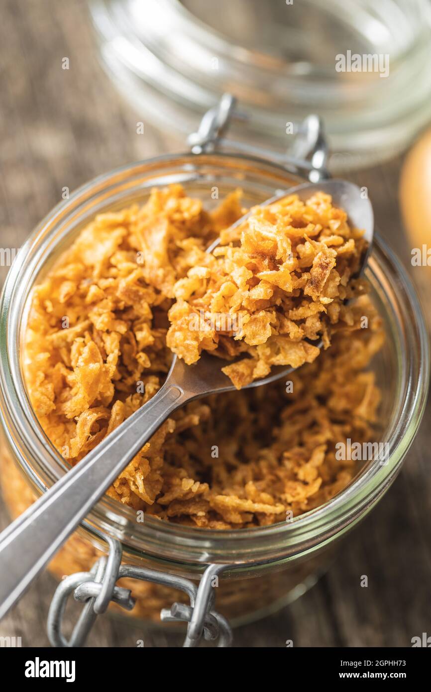 Pezzi di cipolle fritte sul cucchiaio. Foto Stock