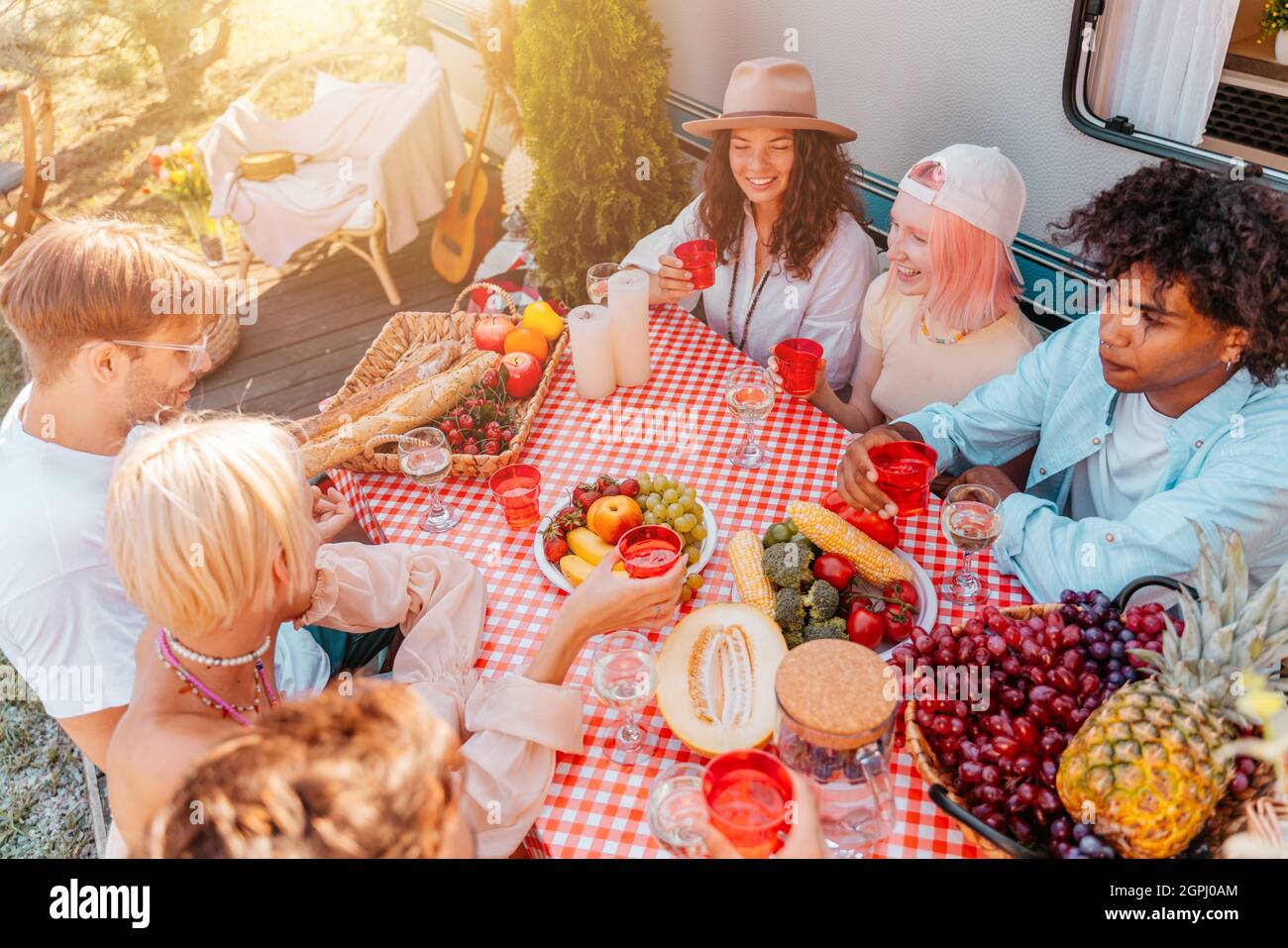 Gli amici hanno un pic-nic con un camper in una giornata di sole Foto Stock