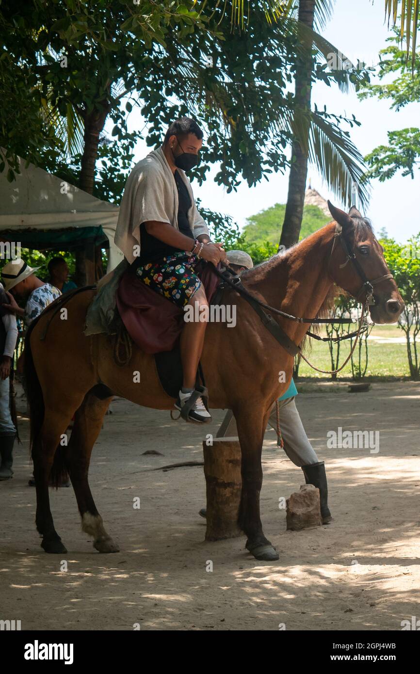 Santa Marta, Magdalena, Colombia - 22 2021 maggio: Un animale stupido ed esplosativo che cavaleggia un cavallo triste in una giornata di sole nel Parco di Tayrona Foto Stock