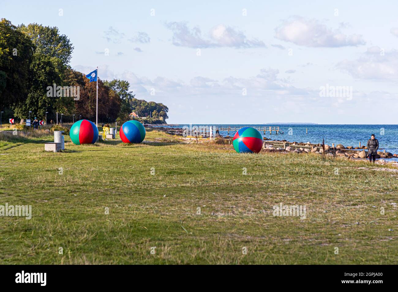 Spiaggia autunnale con scultura di giocoliere giganti a Nyborg, Danimarca Foto Stock