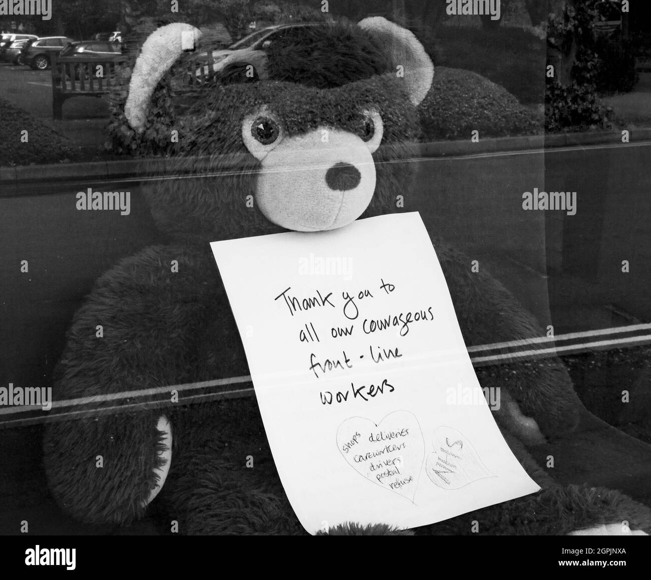 Orso giocattolo in vetrina con un messaggio che ringrazia i principali lavoratori - durante la pandemia di Covid Foto Stock