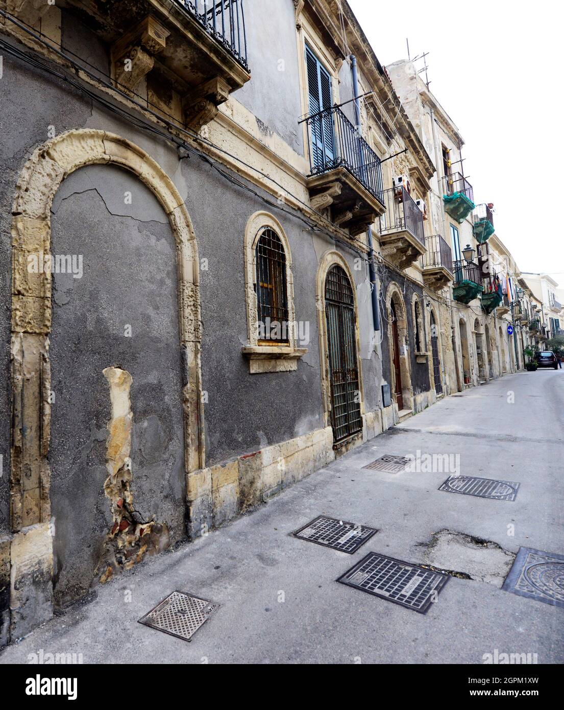 Passeggiando tra i bellissimi palazzi antichi sulle strette stradine dell'isola di Ortigia a Siracusa, Sicilia, Italia. Foto Stock