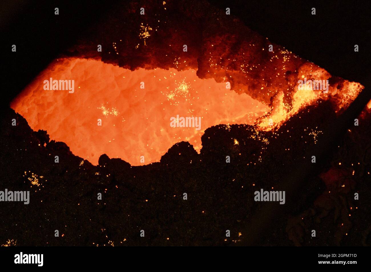 La superficie interna calda della siviera metallurgica. Un foro in una spessa crosta di metallo solidificato Foto Stock