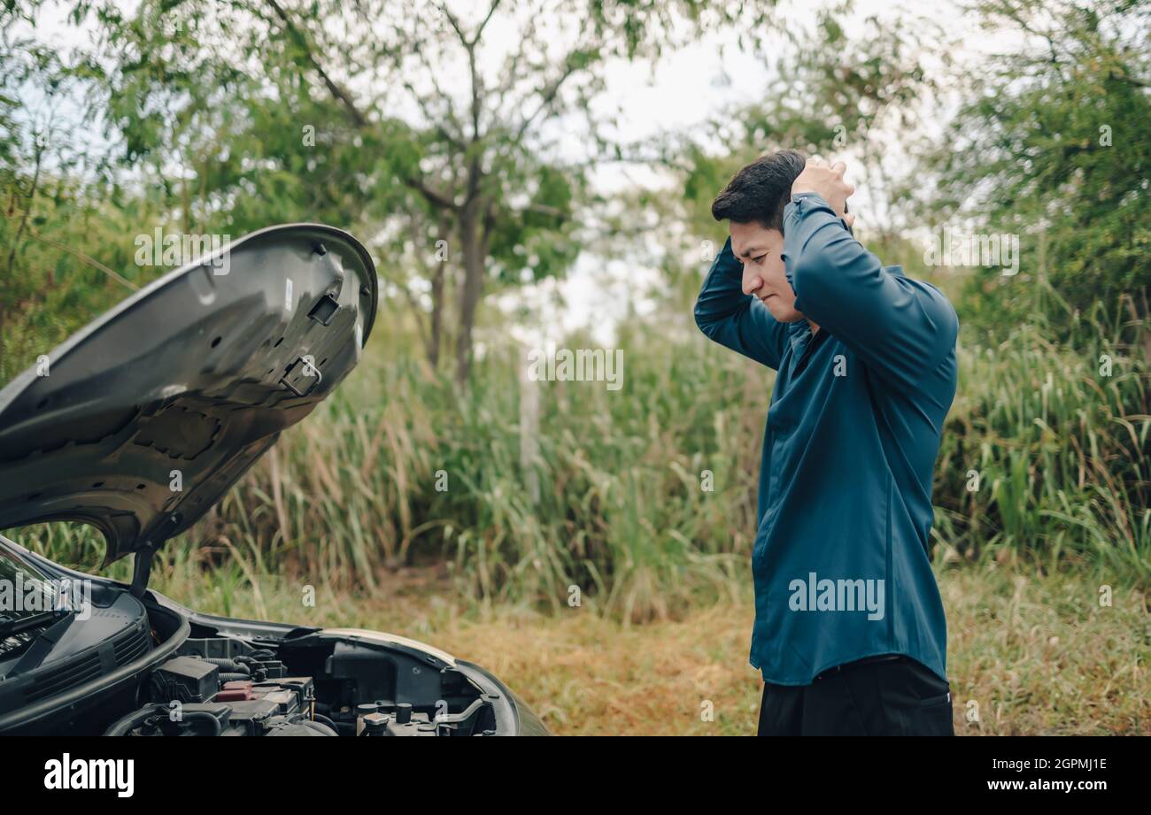 Grave mal di testa davanti all'auto guasto e aprire il cofano sul lato della strada. Concetto di auto rotta. Foto Stock