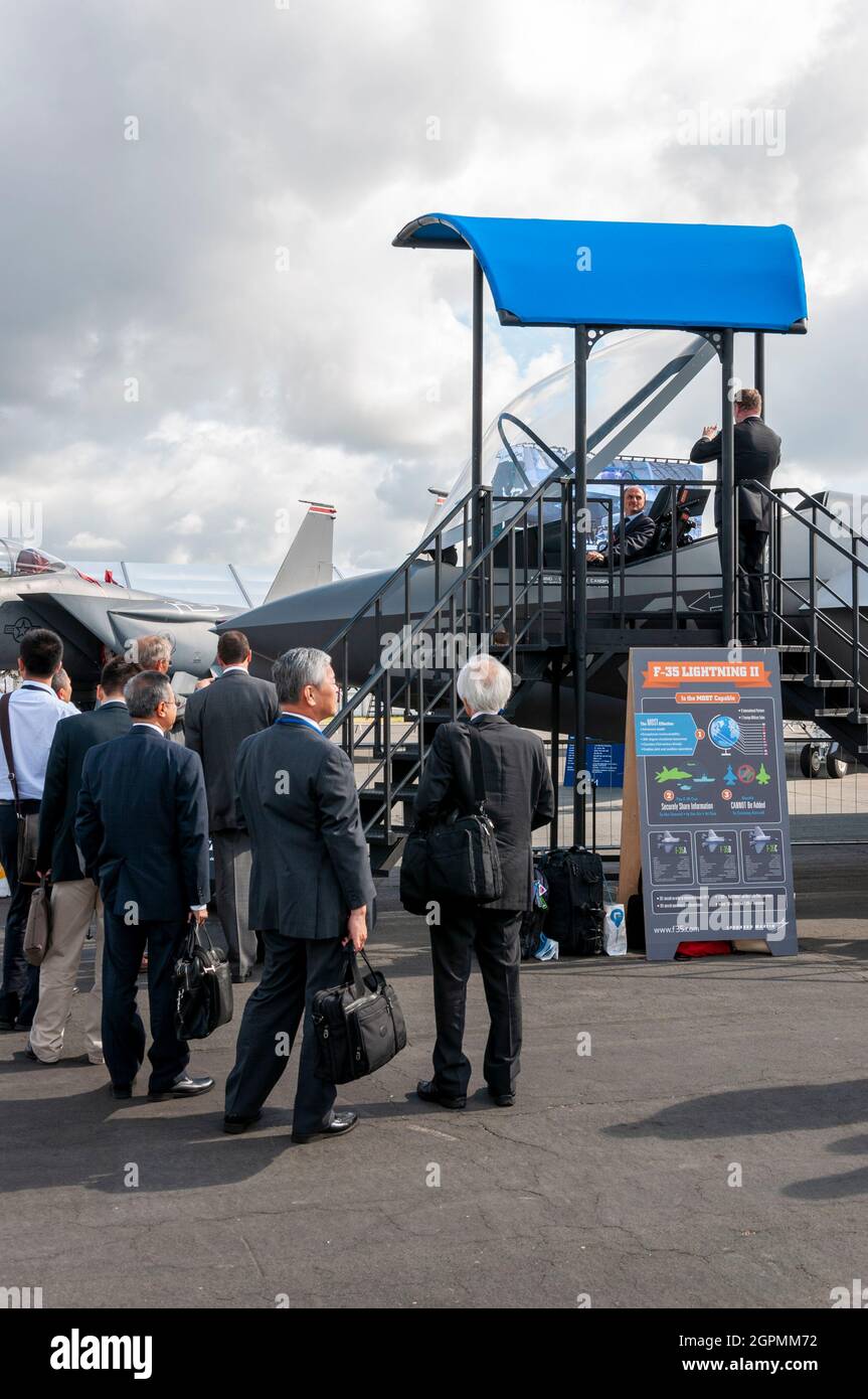 Uomini d'affari che guardano il jet da caccia Lockheed Martin F-35 Lightning II al Farnborough International Airshow. Fiera commerciale. Fiera delle armi militari Foto Stock
