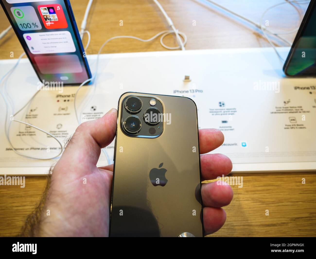 Mano maschile guardando la vista posteriore del triplo migliorato array di telecamere su iPhone 13 Pro Foto Stock