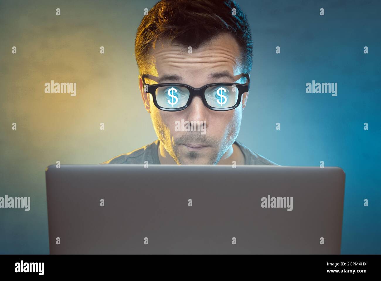 Uomo di fronte ad un computer con i segni del dollaro che riflettono nei suoi occhiali Foto Stock