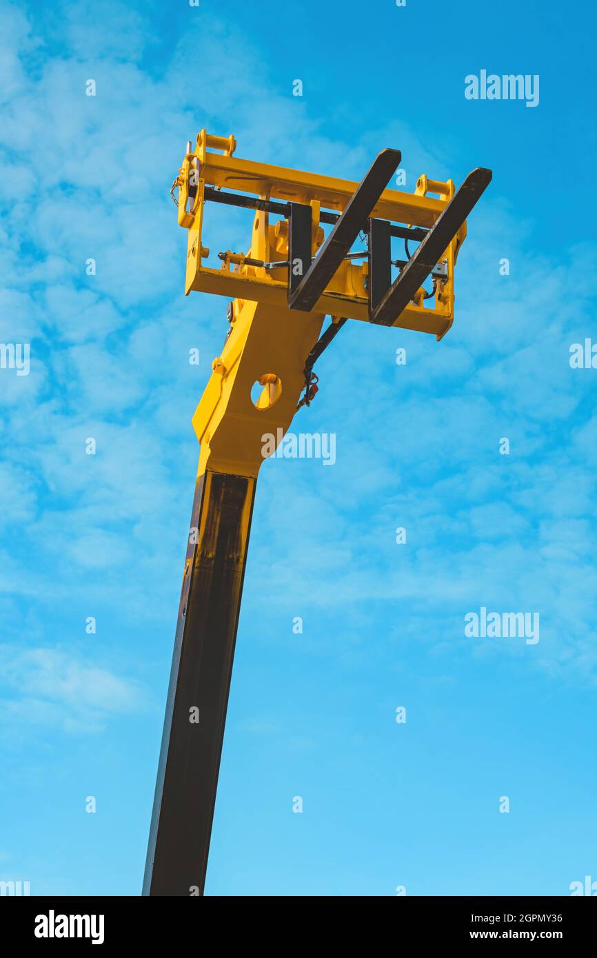 Forche per carrelli elevatori, macchinari industriali e attrezzature contro il cielo blu Foto Stock