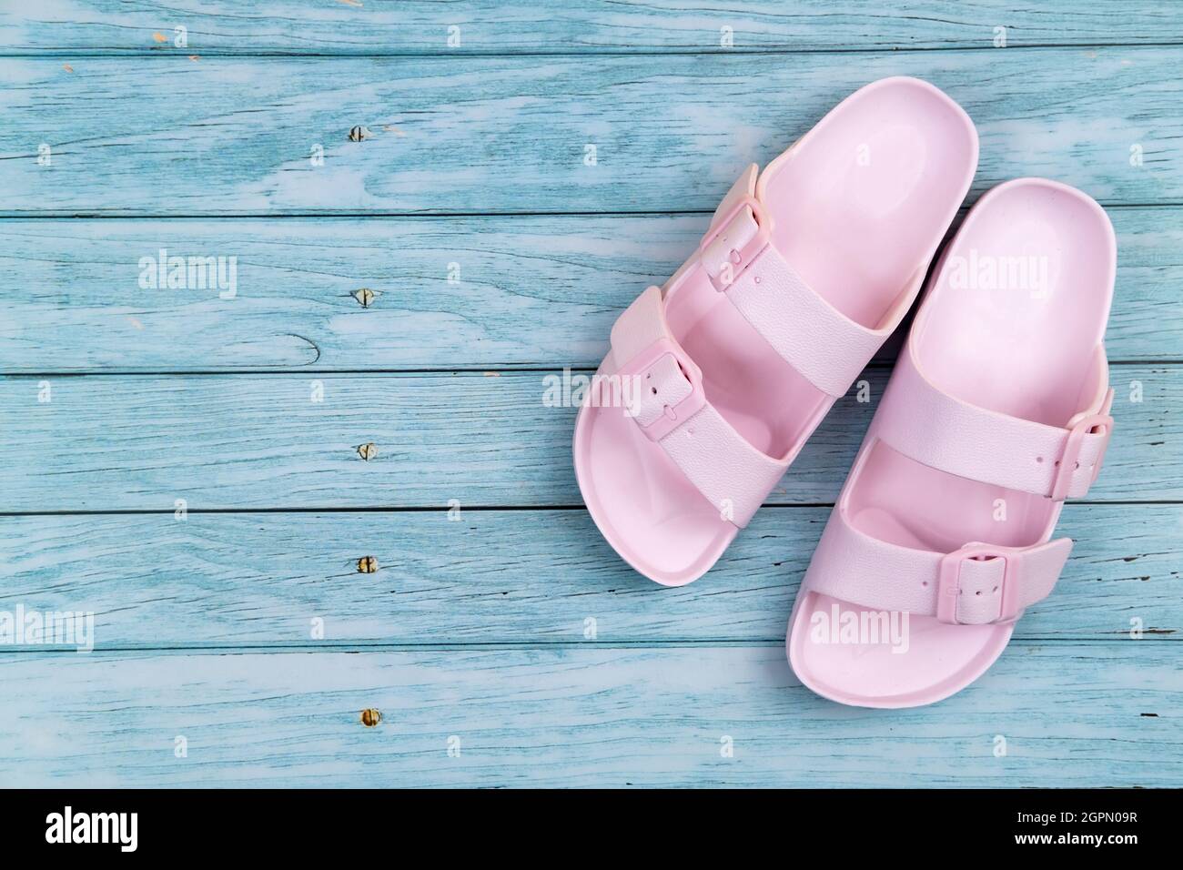 Le sneakers rosa sono su un isolato sfondo di legno blu. Foto Stock