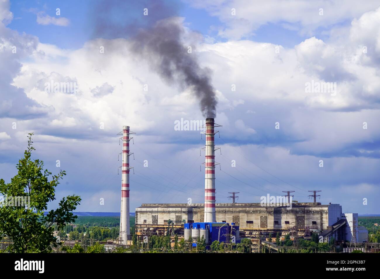 I tubi della centrale termica fumano. Centrale elettrica Trypillian regione di Kyiv. Centrale elettrica cielo blu e fumo nero. Foto Stock