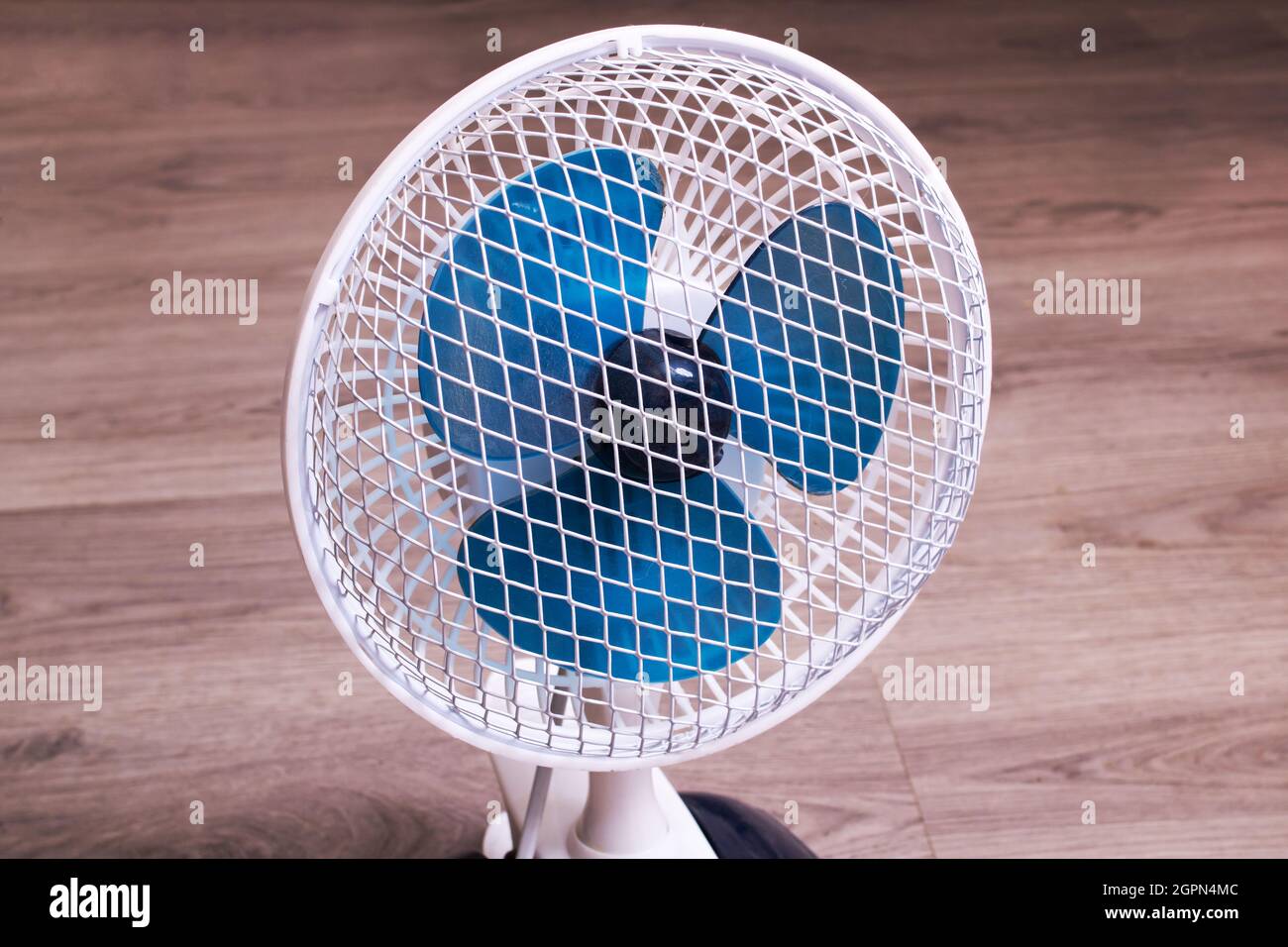 Piccolo ventilatore sul pavimento in legno da vicino Foto Stock