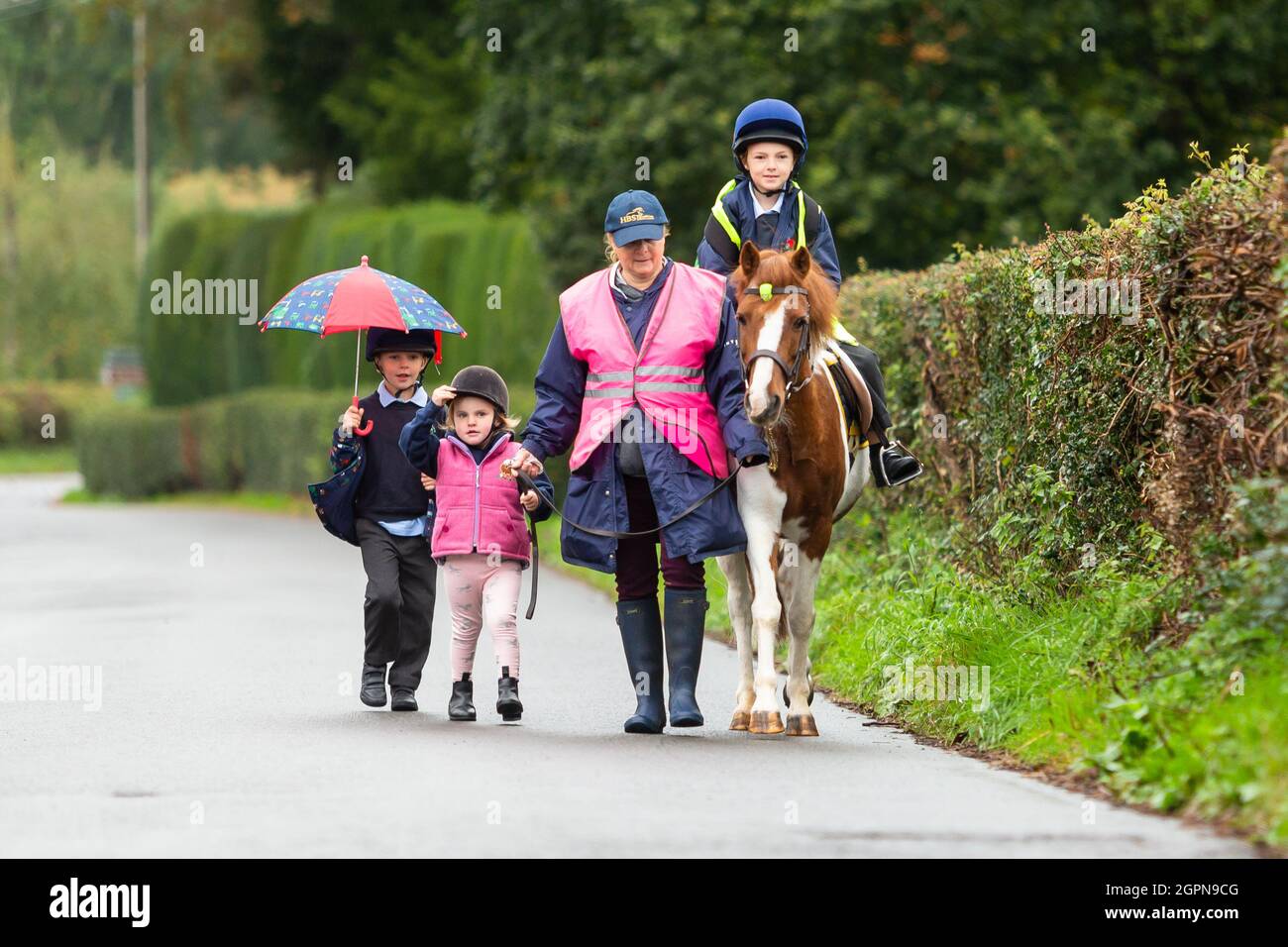 Upper Arley, Worcestershire, Regno Unito. 30 settembre 2021. La nonna Jane Mundie batte la crisi di carenza di carburante utilizzando il suo pony 'Fern' sulla corsa scolastica. I suoi nipoti Reggie, 5, Myla, 2, e Henley, 8, si gira per cavalcare il pony le due miglia per Upper Arley C della scuola elementare e nel Worcestershire rurale. "Al momento non riesco a ottenere il diesel per la mia Land Rover, ma non dobbiamo preoccuparci troppo quando i bambini hanno il nostro pony, Fern. Ed è sicuramente un modo divertente e verde per andare a scuola", afferma Jane. Credit: Peter Lopeman/Alamy Live News Foto Stock