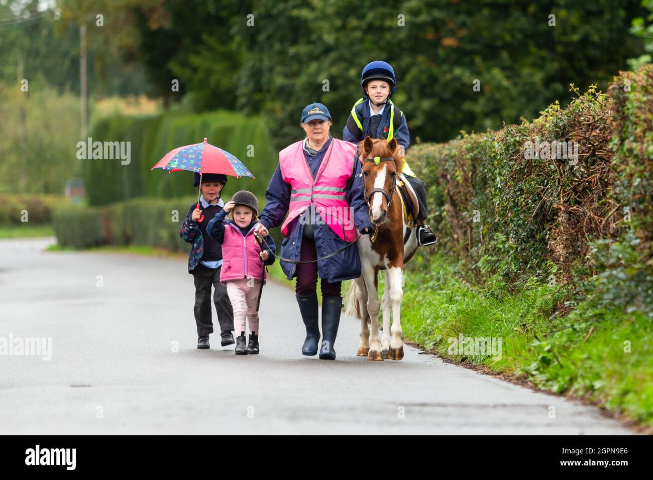 Upper Arley, Worcestershire, Regno Unito. 30 settembre 2021. La nonna Jane Mundie batte la crisi di carenza di carburante utilizzando il suo pony 'Fern' sulla corsa scolastica. I suoi nipoti Reggie, 5, Myla, 2, e Henley, 8, si gira per cavalcare il pony le due miglia per Upper Arley C della scuola elementare e nel Worcestershire rurale. "Al momento non riesco a ottenere il diesel per la mia Land Rover, ma non dobbiamo preoccuparci troppo quando i bambini hanno il nostro pony, Fern. Ed è sicuramente un modo divertente e verde per andare a scuola", afferma Jane. Credit: Peter Lopeman/Alamy Live News Foto Stock